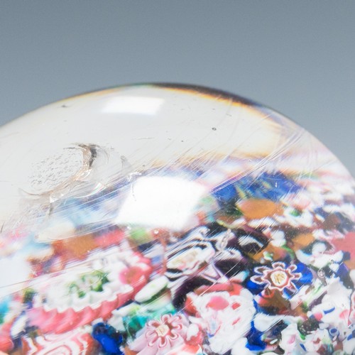 99 - A mid-19th century French Clichy 'scrambled' ground paperweight, with multiple millefiori canes incl... 