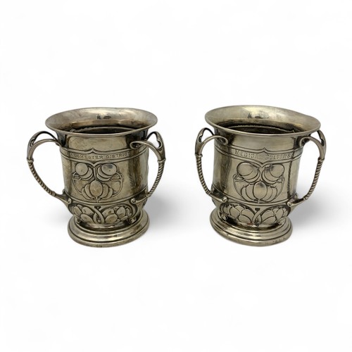 125 - Two Arts & Crafts English silver golfing trophies, in the form of three-handled mugs or tygs, em... 