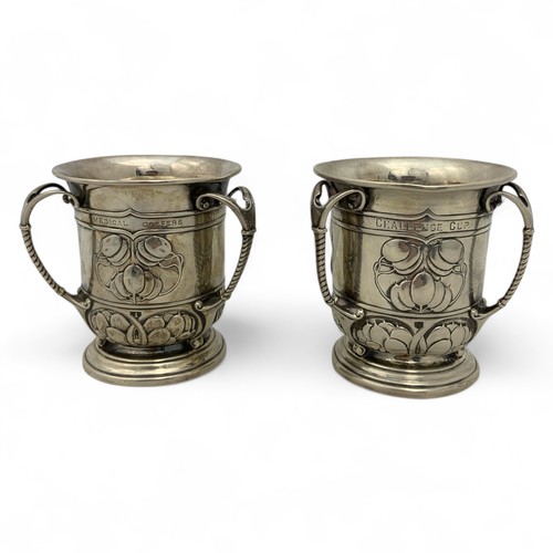 125 - Two Arts & Crafts English silver golfing trophies, in the form of three-handled mugs or tygs, em... 