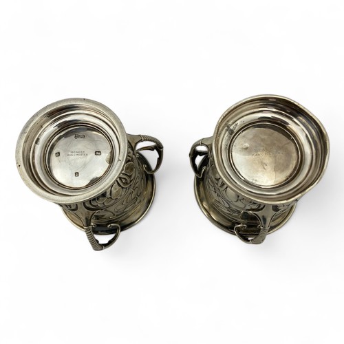 125 - Two Arts & Crafts English silver golfing trophies, in the form of three-handled mugs or tygs, em... 