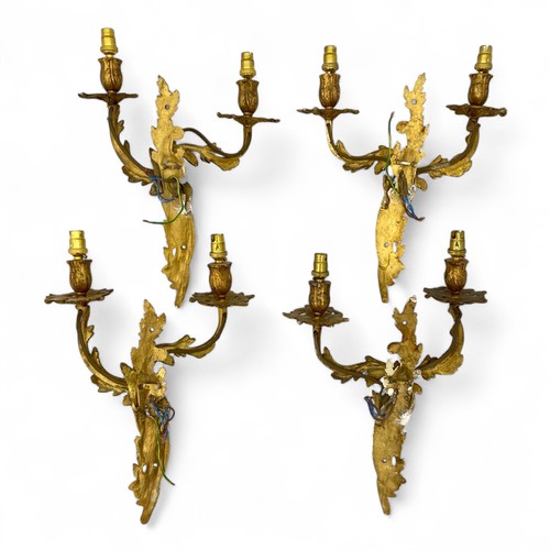 224 - A set of four mid-late 20thC Louis XV style gilt metal Rococo style wall sconces, with leaf and acor... 