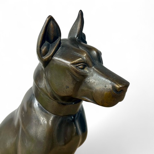 176 - A 1920s-30s French Art Deco patinated spelter sculpture of a dog, resembling bronze, on a yellowy-wh... 