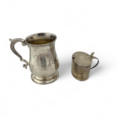 121 - A George II silver tankard, of plain finish with a scroll handle, the body with an erased inscriptio... 