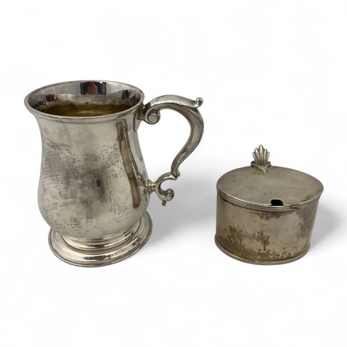 121 - A George II silver tankard, of plain finish with a scroll handle, the body with an erased inscriptio... 