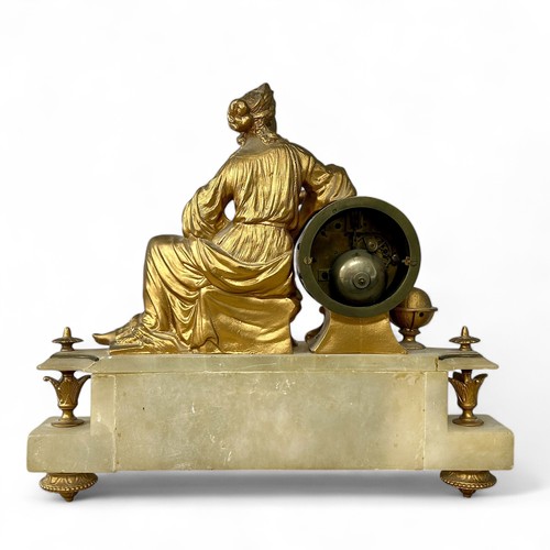 169 - A late 19thC Neoclassical style alabaster and gilt metal clock, with a reclining lady holding calipe... 