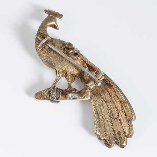 153 - A late 19th century silver gilt peacock shaped brooch, probably central European, the peacock standi... 