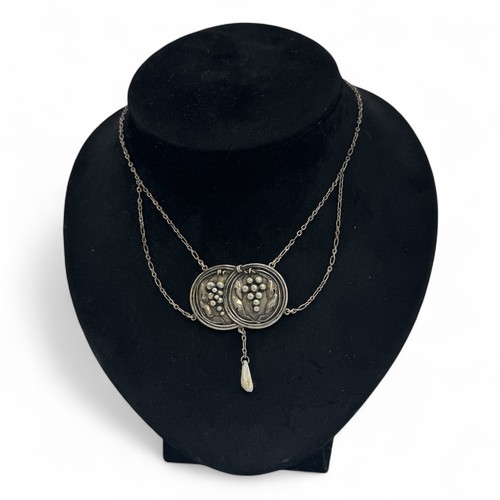 122 - An early 20thC Arts & Crafts silver pendant necklace, two intersecting discs decorated with baro... 