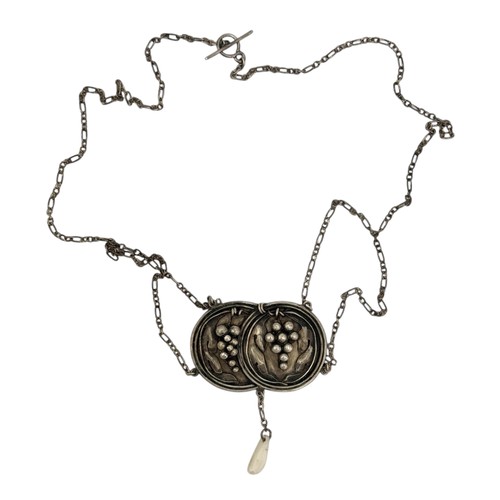 122 - An early 20thC Arts & Crafts silver pendant necklace, two intersecting discs decorated with baro... 