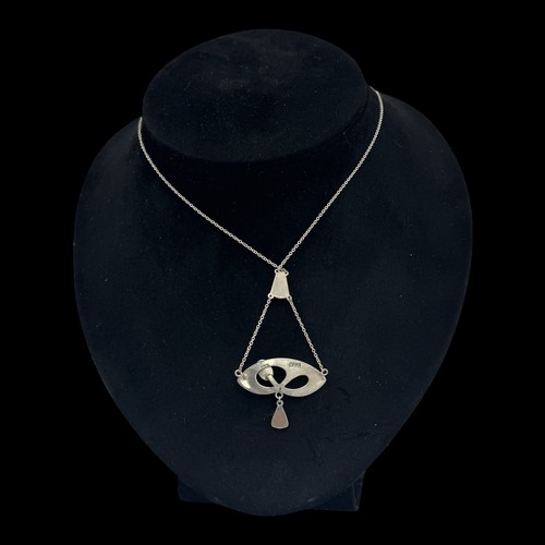 143 - A Charles Horner silver and enamel pendant, decorated with an openwork design set with  a dark green... 