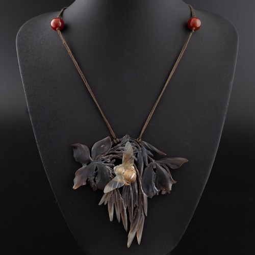 138 - An early 20thC French Art Nouveau carved horn pendant, probably by Elizabeth Bonté, modelled as a wi... 