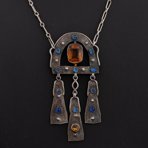 110 - An early 20thC Arts and Crafts white metal pendant and chains, pendant horseshoe-shaped decorated wi... 
