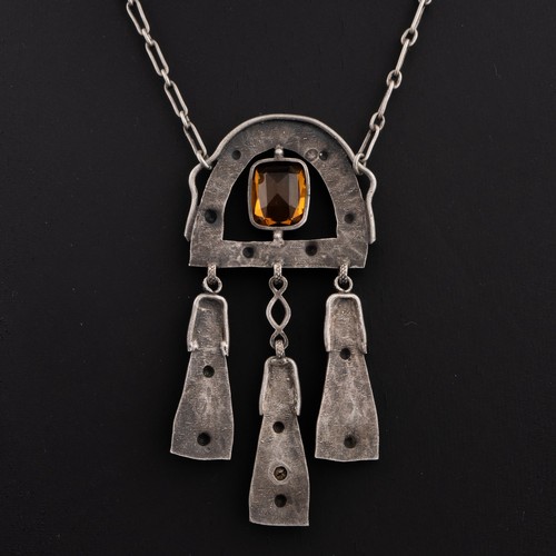 110 - An early 20thC Arts and Crafts white metal pendant and chains, pendant horseshoe-shaped decorated wi... 