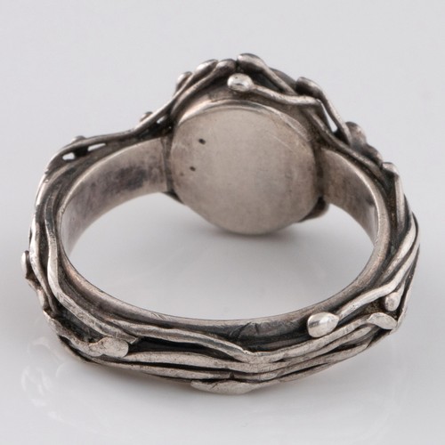 87 - An English Arts and Crafts silver ring, c.1905, decorated with an intricate design of entwined stems... 