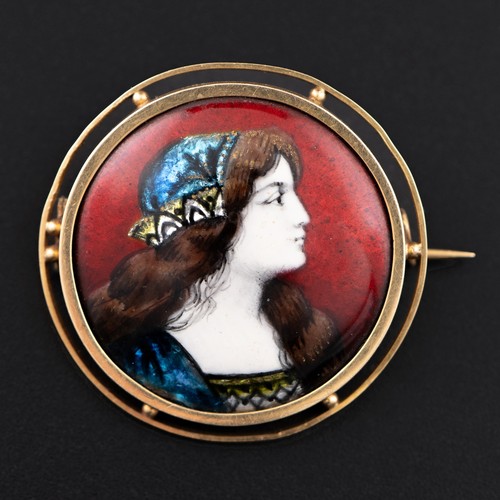 95 - An early 20thC Limoges enamel on copper brooch, depicting a young lady wearing an iridescent blue an... 