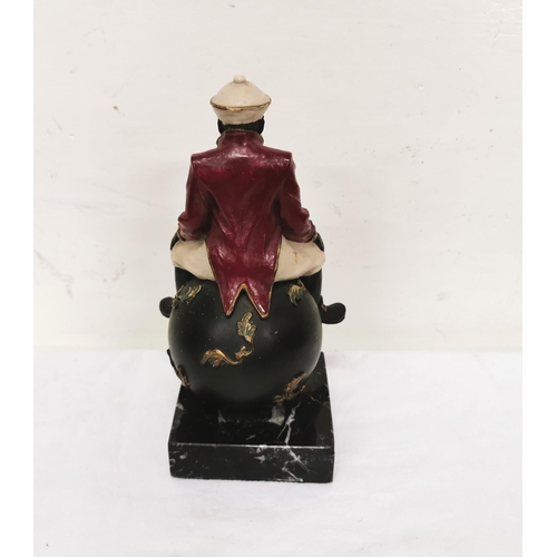 220 - Painted figure of a seated blackamoor, on a black marble base, 23cmH