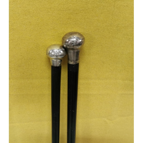 556 - 2 antique Walking Sticks, ebony coloured, with English silver tops