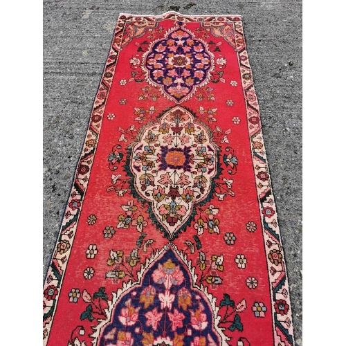 376 - Persian Tabriz Runner, red ground with a treble medallion design, 2.32M x 0.80M