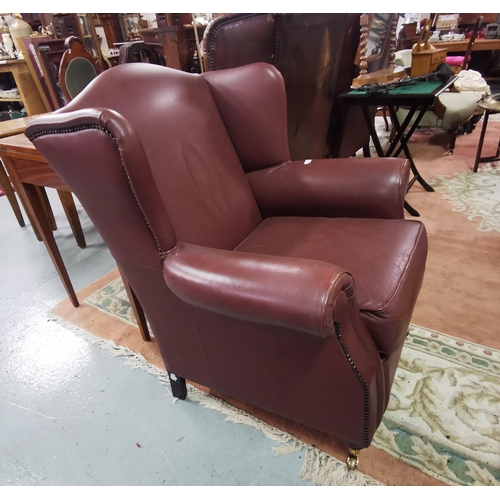 14 - Brown Leatherette Covered Armchair, with good seat and back, on raised round legs with brass castors