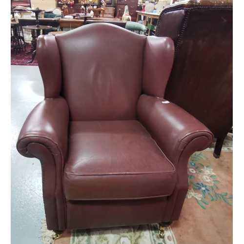 14 - Brown Leatherette Covered Armchair, with good seat and back, on raised round legs with brass castors