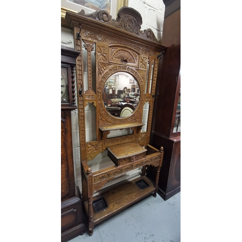 169 - Edw. Carved Oak Hall and Stick Stand, with a circular shaped mirror back, large sized, 242cmH x 107W... 