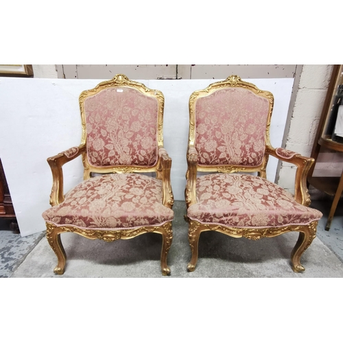 18 - Matching Pair of carved Gilt Wood Framed Armchairs, the backs and seats covered with red and gold fa... 