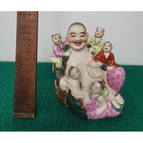 326 - Coloured bisque figure of a seated laughing Buddha with children, 13cmH x 15cmW