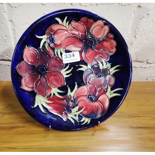 334 - Moorcroft Cabinet Plate, blue glazed with pink floral detail, stamped at the back and signed, 26cm d... 