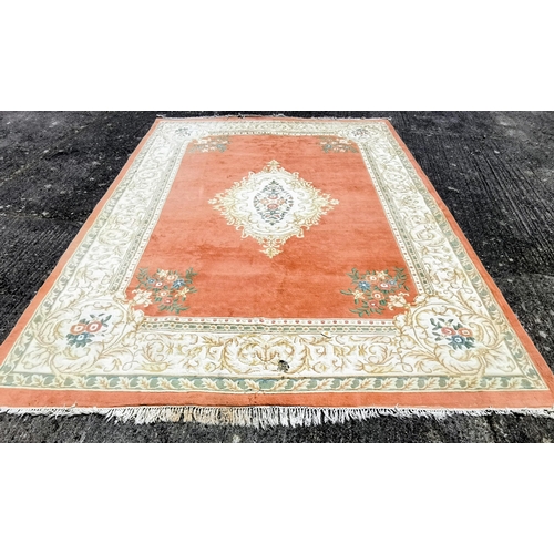 399 - Large Chinese Wool Floor Rug, pink ground with central cream and green floral medallion (2 holes to ... 