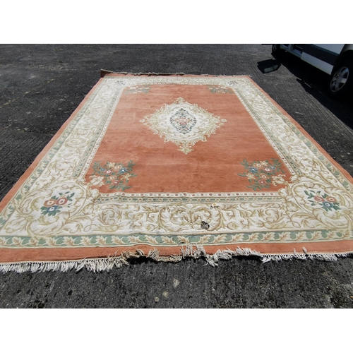 399 - Large Chinese Wool Floor Rug, pink ground with central cream and green floral medallion (2 holes to ... 