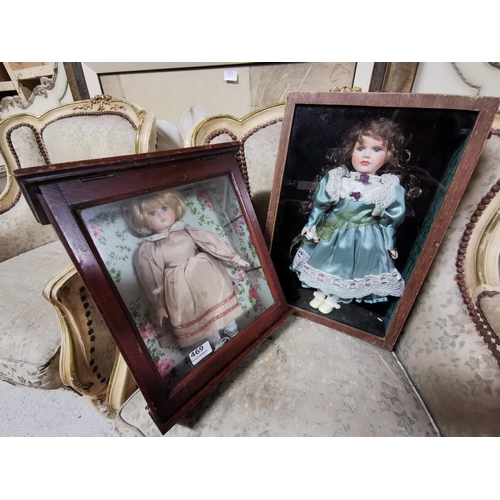 469 - 2 Porcelain Dolls, in shop display cases (1 green dress, 1 brown dress)