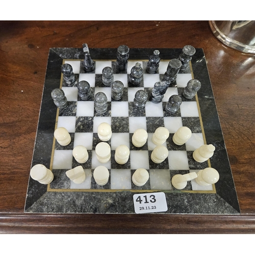 413 - A Marble Chess Board 25cm sq with white and grey marble chess pieces (each 4cmH)