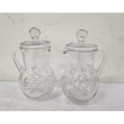 496 - A pair of cut glass Water Jugs with Lids (wave shaped patterns), each 27cm tall (as new) (2)