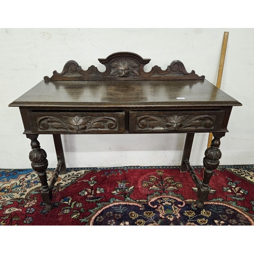 70 - Early 20thC Oak Side Table with a gallery back, the two drawers featuring carved mask head figures 1... 