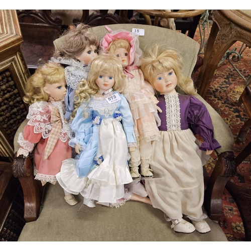 573 - 8 porcelain Dolls, wearing blue, pink etc costumes