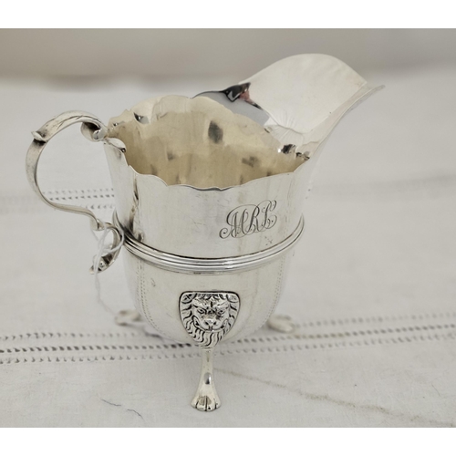 218 - Irish Silver Cream Jug, hallmarked West & Son 1919, raised on three lion mask and paw feet, inscribe... 