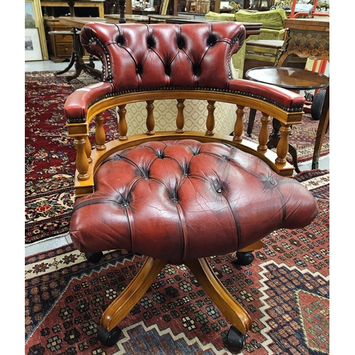 25 - Modern Office Armchair, tub shaped, covered with red leatherette, buttoned seat and back, on a swive... 