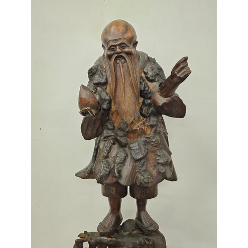 355 - 19thC carved Chinese root-wood Figure of an Immortal, carrying an orb, (detachable from the base), 8... 