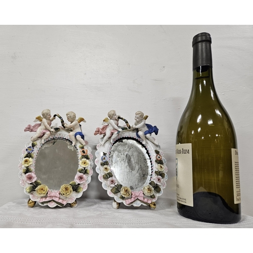 418 - Pair of early 20thC small Dresden framed Wall Mirrors, oval shaped, 2 cherubs on the pediment, 18cmH... 