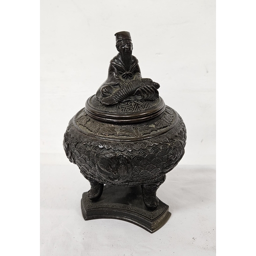 129 - Bronze Oriental Lidded Sensor - a figure of a man with fish on a bulbous body with fish designs on t... 