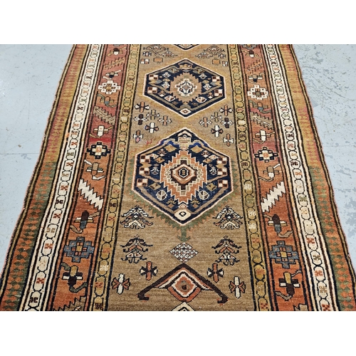 239 - Large dark gold ground vintage Persian Heriz runner, medallion design, with a surrounding terracotta... 