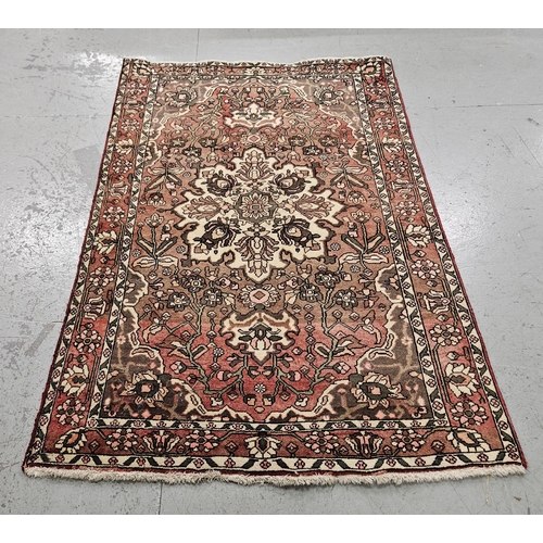 251 - Washed red ground vintage Persian Heriz Rug, hand woven with a floral pattern, 1.95m x 1.35m