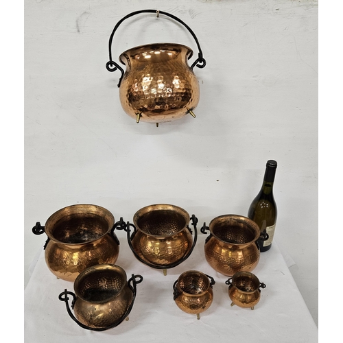 366 - Vintage Graduating Set of 7 beaten copper ornamental skillet pots with handles, each on 3 brass feet... 