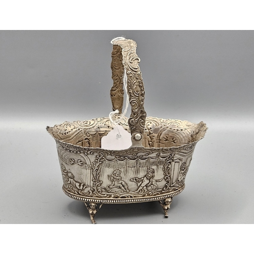 4 - Continental Silver Swing Handled Basket, oval shaped, decorated in relief with cherubs at play, rais... 