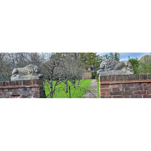 62 - A PAIR OF RECUMBENT STONE LIONS, reconstituted stone.
71cm x 34cm