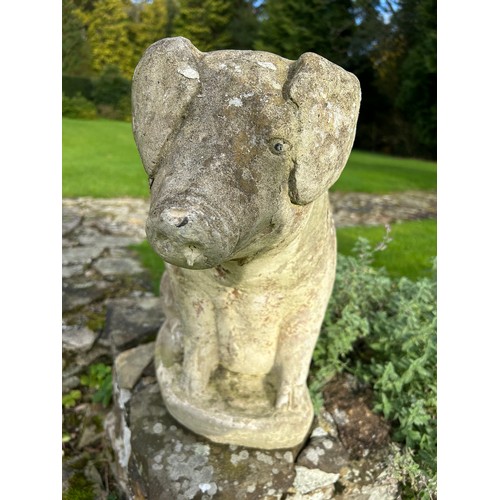 61 - A PAIR OF RECUMBENT STONE PIGS, reconstituted stone.
54cm and 45cm in height