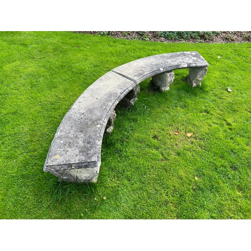 68 - A reconstituted stone curved garden bench on five scroll supports, each marked 