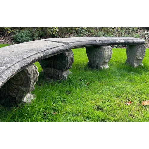 68 - A reconstituted stone curved garden bench on five scroll supports, each marked 