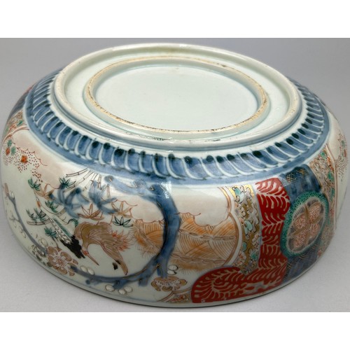 177 - A JAPANESE PORCELAIN BOWL, decorated with imagery of cranes and blossom trees in the Imari palette.