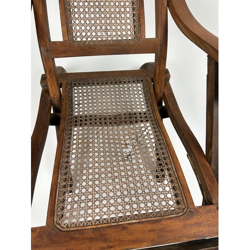 96 - A RECLINGING STEAMER ARMCHAIR CIRCA 1920, rattan cane panelled.