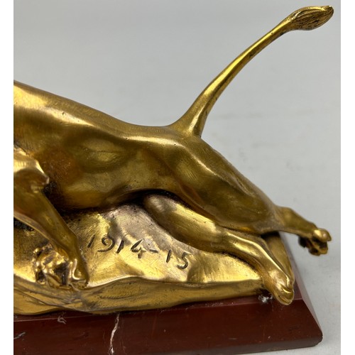 181 - A SCULPTURAL GILT BRONZE OF A LION, mounted on a red marble base and signed indistinctly.

16cm in l... 